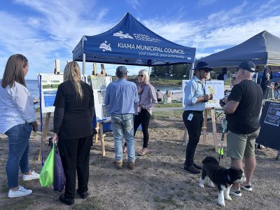 Outdoor market scene with people walking among colorful stalls